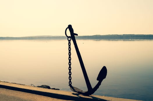 Anchor on the shore. anchor stands on the pier. marine background