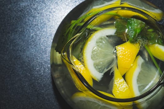Drink with lemon and mint. homemade lemonade. glass jug with refreshing beverage