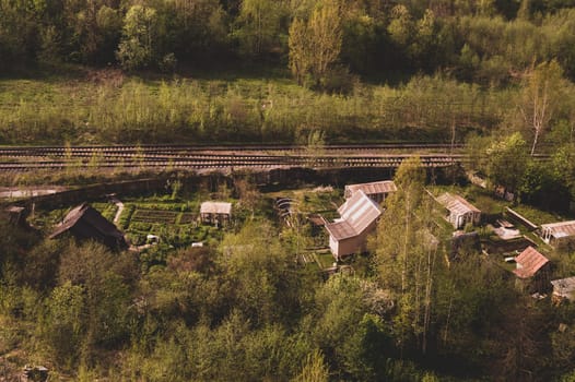 House with the garden near railway lines. wooden house in the forest aerial view. rural landscape from high view