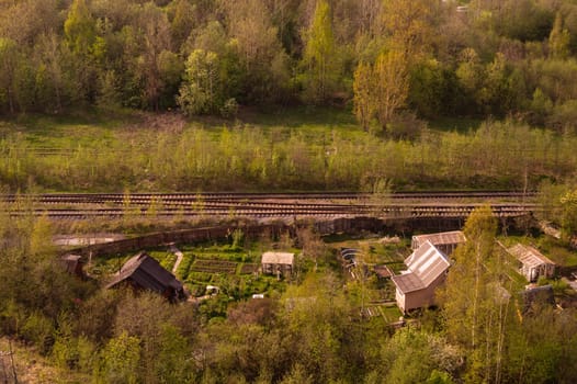 House with the garden near railway lines. wooden house in the forest aerial view. rural landscape from high view
