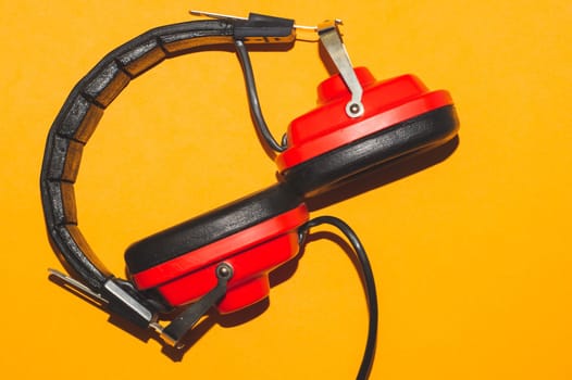 Vintage red headphones on yellow background. retro earphones