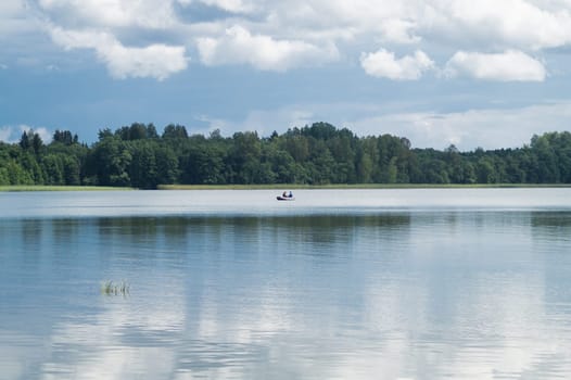 Fishermen catching fish on the lake. fishers on a fishing boat. calm background
