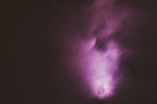 Violet smoke on black backdrop. color fog abstract background