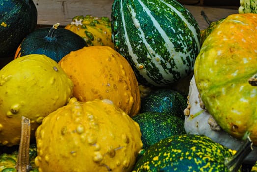 A variety of pumpkins in a wooden box on the market, selective focus, autumn background