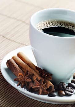 Cup of coffee with cinnamon and coffee beans