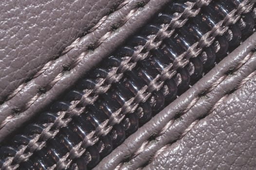 Leather background with zipper closure. material with seams close up