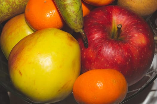 Ordinary fruit plate with natural looking fruits. fresh apples, pears and mandarins