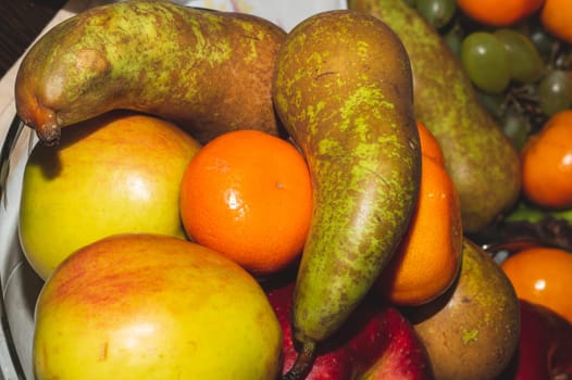 Ordinary fruit plate with natural looking fruits. fresh apples, pears and mandarins
