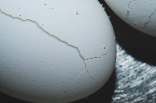 Cracked egg boiled in a pot with hot water close up