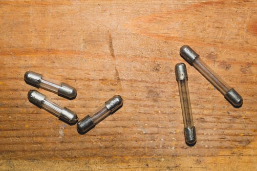 Fuse on wooden background. safety device for overcurrent protection. protection of an electrical circuit