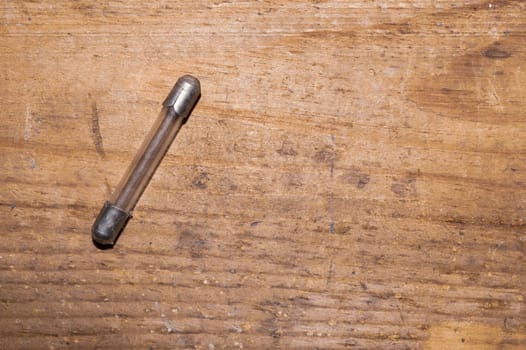 Fuse on wooden background. safety device for overcurrent protection. protection of an electrical circuit