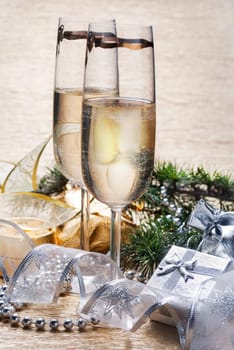 Two champagne glasses with presents and decorative ribbon