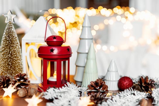 Christmas or New Year composition with various home decorations, different symbolic toys composed and ordered at coffee table with blurred Christmas lights background at sofa white cover. Family time