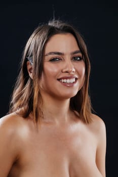 Beautiful topless woman with a big smile over a black background.