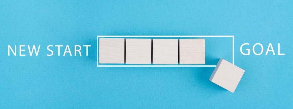 New start, achieving new goals, loading bar with wooden cubes, blue colored background, business concept