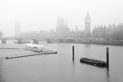 A black and white image of fog descending on the River Thames with Parliament