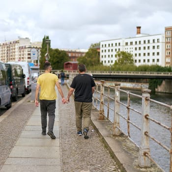 Footpath on the bank of the river Spree in Berlin with homosexual couple walking