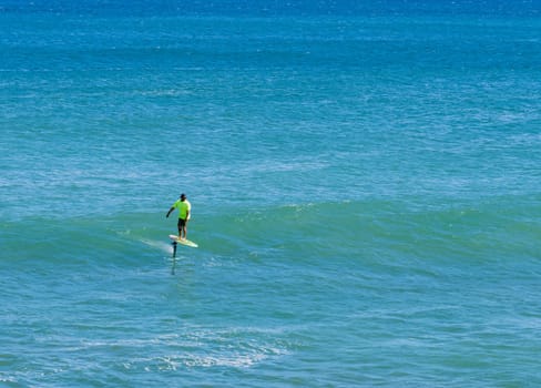 Anahola, Kauai - 1 February 2025: A hydrofoil surfer enjoys the waves at Anahola Beach Park, Kauai, Hawaii