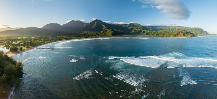 Aerial panoramic image at sunrise off the coast over Hanalei Bay and pier on Hawaiian island of Kauai