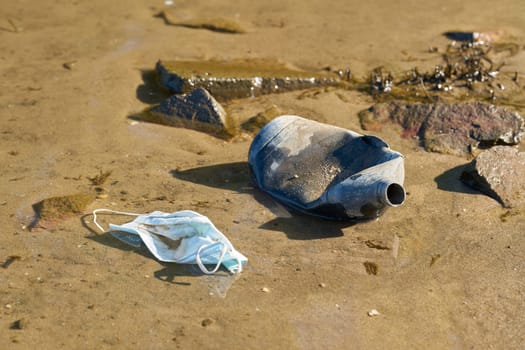 Bottle made of plastic and face mask on the bank of the Elbe near Magdeburg