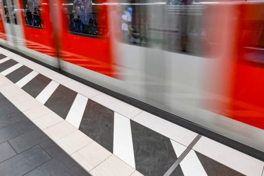 blurred red train in motion at the metro platform