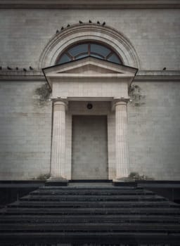 Hidden door in the wall. Doorway camouflage, covered with limestone masonry. Fake entry in the building