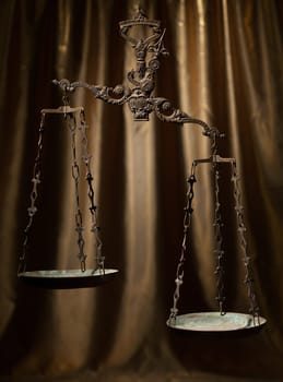 Antique rusty weighing scale on golden background.