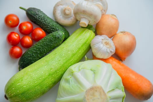 Vegetables and porcini mushrooms lie on a white background. High quality photo