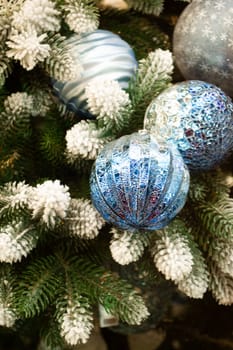 Christmas blue balls on the branches fir. Vertical image