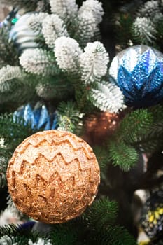 Closeup of festively decorated Christmas tree with bright blue and beige balls. Vertical image
