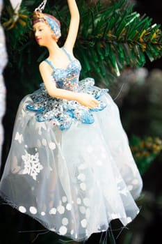 Ballerina toy decoration on a Christmas tree branch. Vertical image