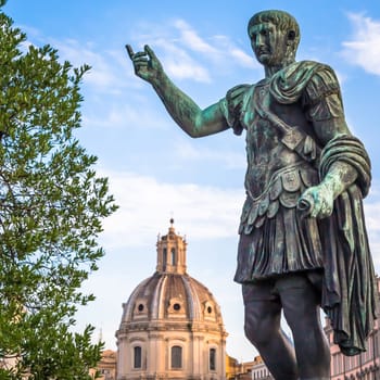 ITALY, ROME - CIRCA AUGUST 2020: Statue of Caesar Emperor, made of bronze. Natural sunrise light. Ancient  role model of Leadeship and Authority .