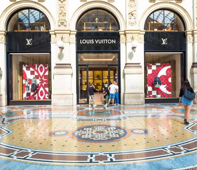 MILAN, ITALY - CIRCA SEPTEMBER 2020: Fashion shopping in Vittorio Emanuale's Gallery. People walking in front of a famous luxury boutique.