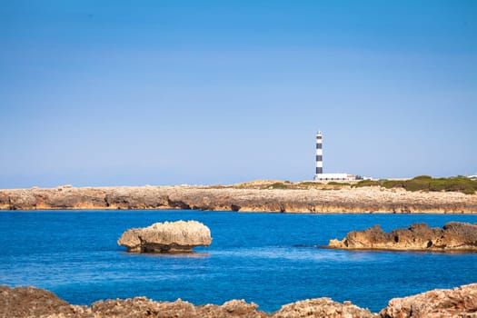 MINORCA ISLE - SPAIN - CIRCA AUGUST 2020: scenic Artrutx Lighthouse at sunset, famous landmark of the Isle