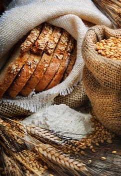 Bread and wheat ears on vintage wooden board