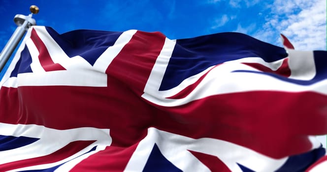 The national flag of the United Kingdom flying in the wind. Outdoors and sky in the background.