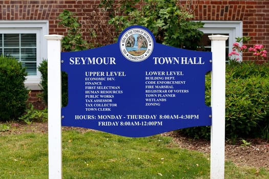 Seymour, CT, USA - May 28, 2021: Sign in front of Seymour town hall showing what offices are located on the upper and lower level along with days and hours. Seymour town hall directory sign to offices