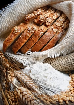 Bread and wheat ears on vintage wooden board