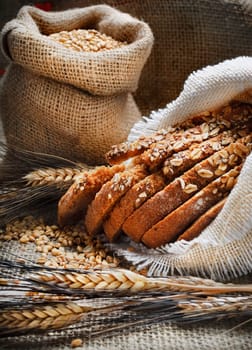 Bread and wheat ears on vintage wooden board