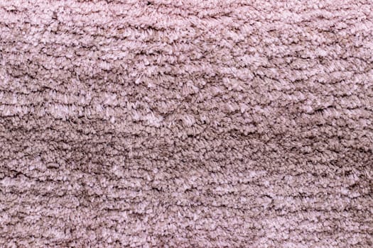 Red brown fabric texture. Close-up of a pink fluffy soft bath mat or rug or textile background. Macro photograph. Beautiful bright backdrop.