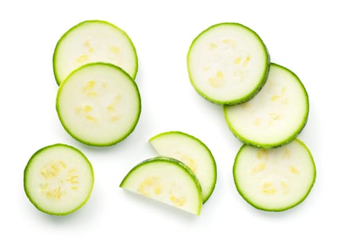 Pieces of sliced zucchini isolated over white background. Flat lay, top view