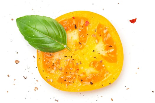 Yellow tomato slice with basil and spices, pepper, salt. Composition isolated on white background. Top view. Flat lay