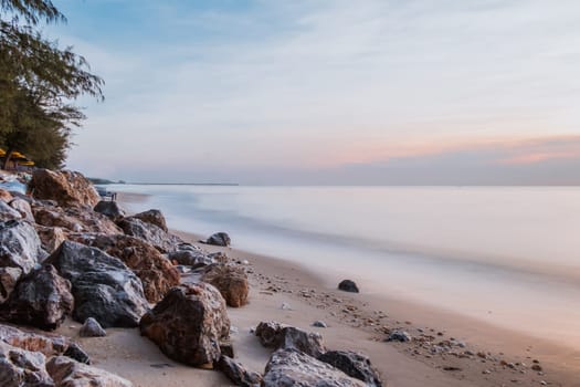 long exposure Sea rocks landscape Magnificent sunrise view at sunrise Romantic atmosphere in peaceful morning at sea. Pink horizon with first hot sun rays.