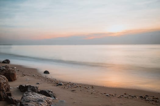 long exposure Sea rocks landscape Magnificent sunrise view at sunrise Romantic atmosphere in peaceful morning at sea. Pink horizon with first hot sun rays.