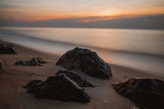long exposure Sea rocks Magnificent sunrise view at sunrise Romantic atmosphere in peaceful morning at sea. Pink horizon with first hot sun rays.