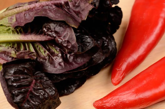 Lettuce and red peppers on a wooden board