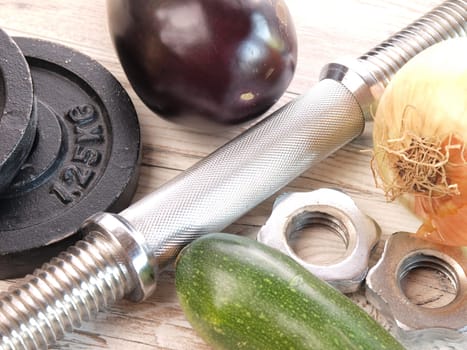 Healthy food with sport equipment on a wooden floor