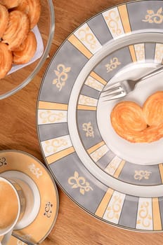 Puff pastry cookies on a plate with a cup of coffee