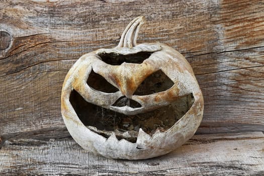 A creepy dried up old pumpkin head with spider webs