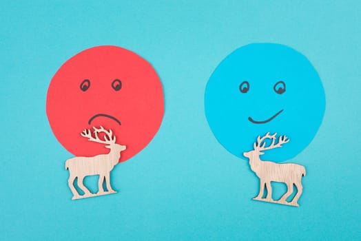 An angry and a smiling face behind two reindeers, customer rating, christmas season, concept, blue background